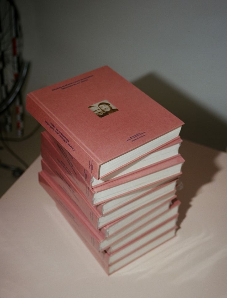 a stack of pink books sitting on top of a table