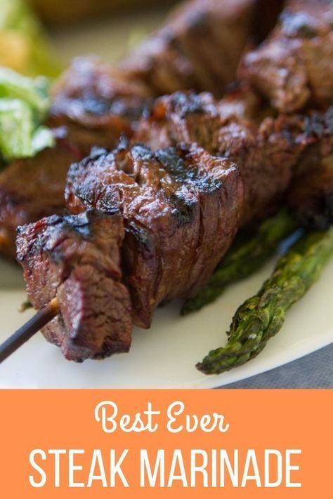 a close up of a plate of food with meat and asparagus on it