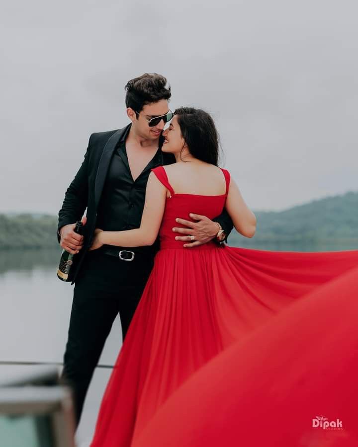 a man in a tuxedo kissing a woman in a red dress