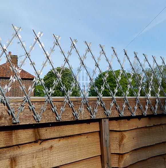 a wooden fence with barbed wire on top