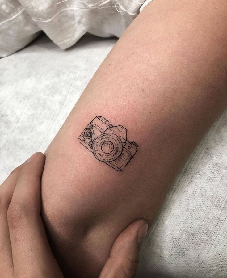 The 90 Most Popular Symbols For Travel Tattoos | Unique & Cute Travel Tattoo Ideas Cute Camera Tattoo Ideas, Small Tattoos Camera, Camera Mini Tattoo, Small Tattoos Photography, Arm Tattoo Photography, Small Typewriter Tattoo, Photo Camera Tattoo, Vintage Camera Tattoo Design, Camera Minimalist Tattoo