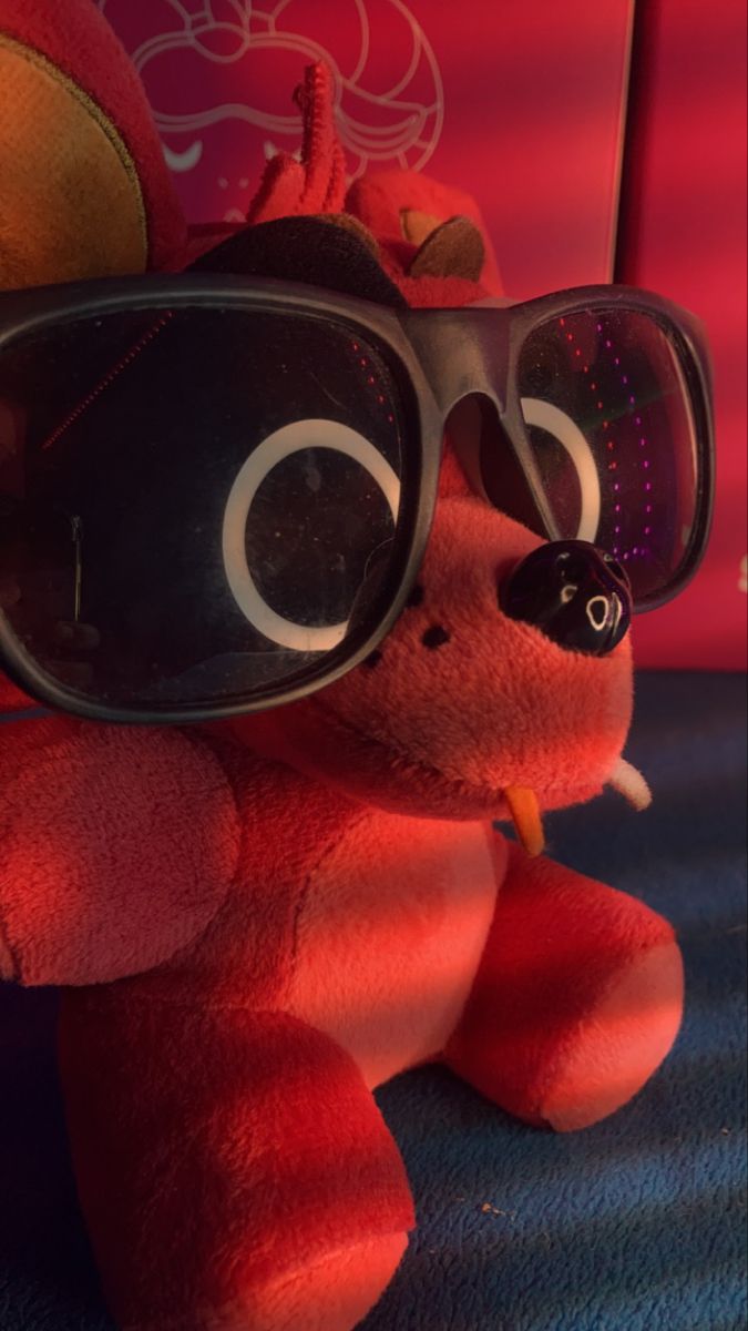 a red stuffed animal with sunglasses on it's head