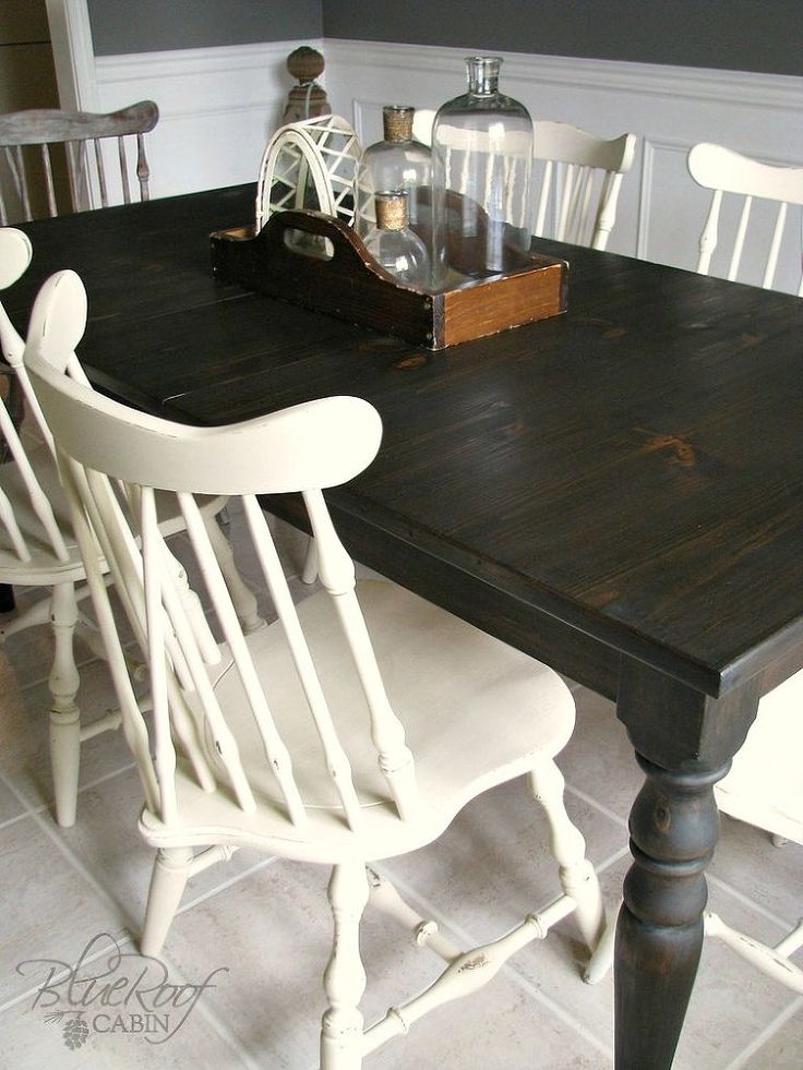 a black table with white chairs and a clock on the wall