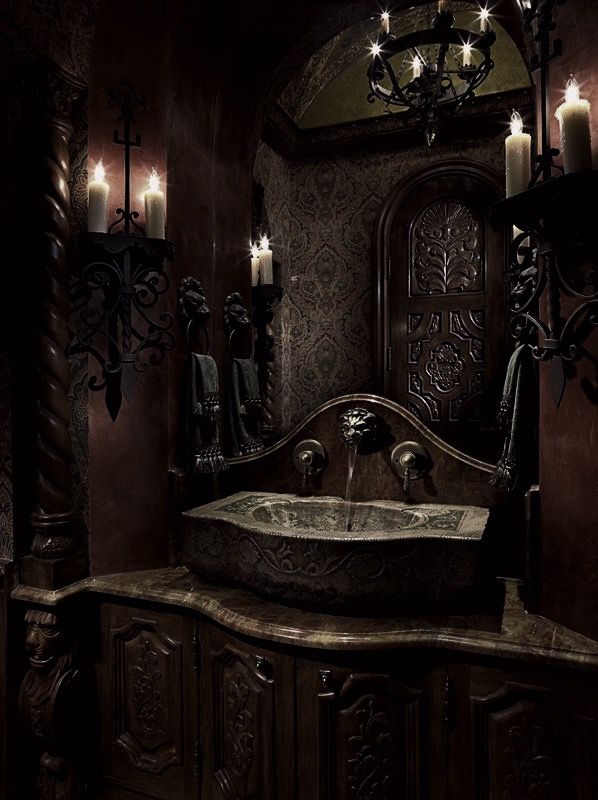 a fancy bathroom with candles on the wall and an ornate sink in the middle,