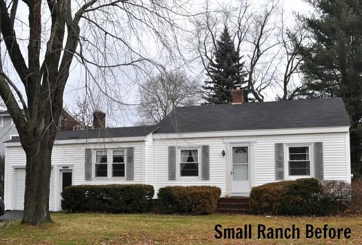 a small white house sitting next to a tree