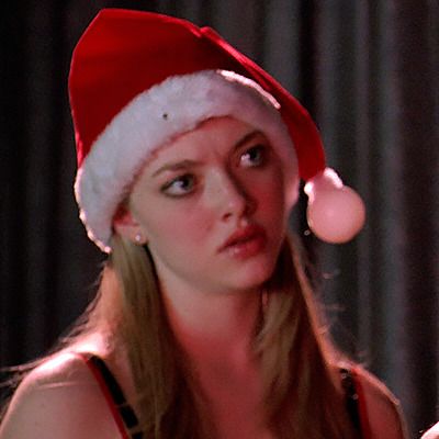 a woman wearing a santa hat holding a cell phone