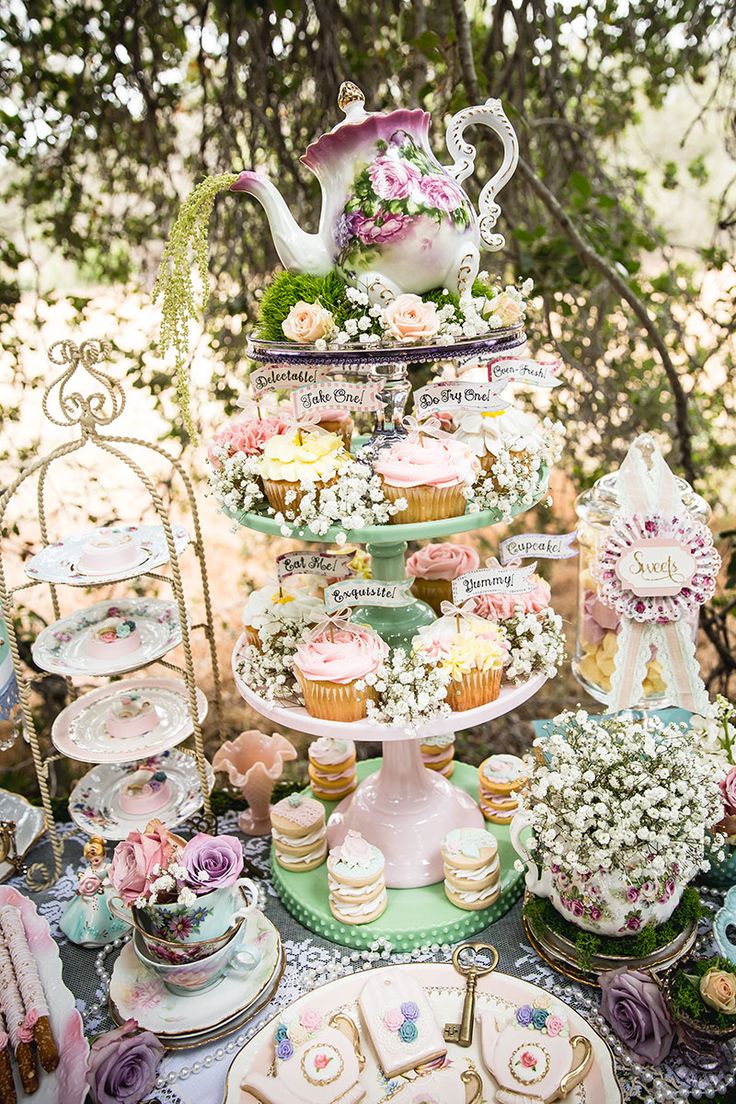 a table topped with lots of cakes and cupcakes