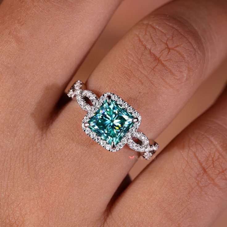 a woman's hand with a ring on it and a blue diamond in the middle