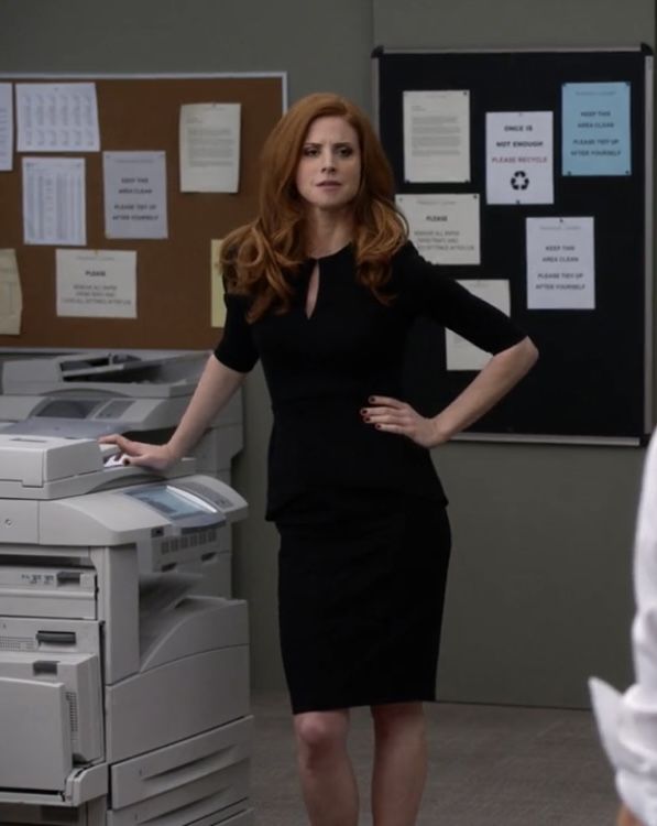 a woman standing next to a printer in an office