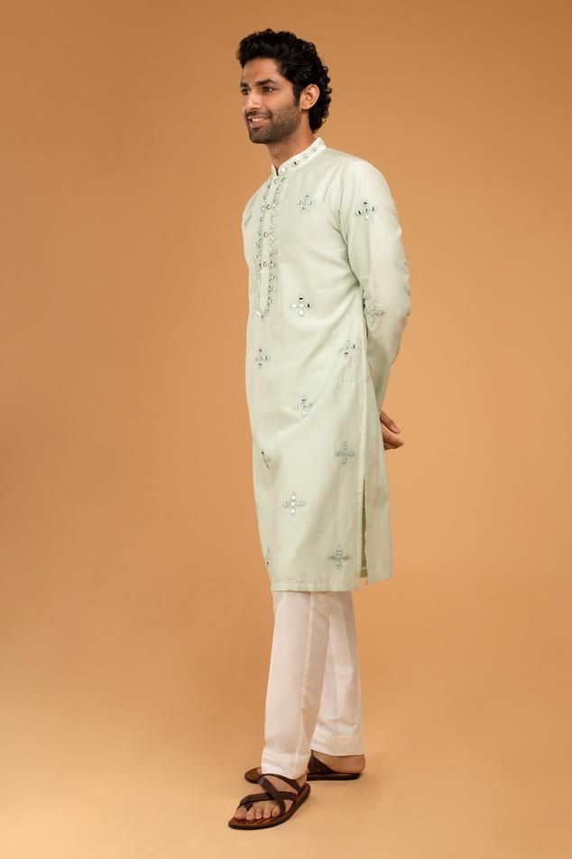 Mint green full sleeve kurta with mirror placement embroidery and mandarin collared neckline. Paired with pyjama pant.
Components: 2
Pattern: Embroidery
Type Of Work: Mirror
Neckline: Mandarin collar
Sleeve Type: Full sleeves
Fabric: Cotton Silk
Color: Green
Other Details: 
Front button detailing
Occasion: Mehendi and Puja - Aza Fashions Kurta And Pants, Embroidery Mirror, Blouse Yoke, Kurta Set For Men, Personal Shopping Service, Green Mirror, Green Mirrors, Pajama Pant, Silk Embroidery