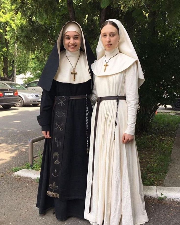 two women dressed in nun costumes standing next to each other