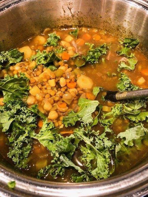 a pot filled with soup and vegetables on top of a stove