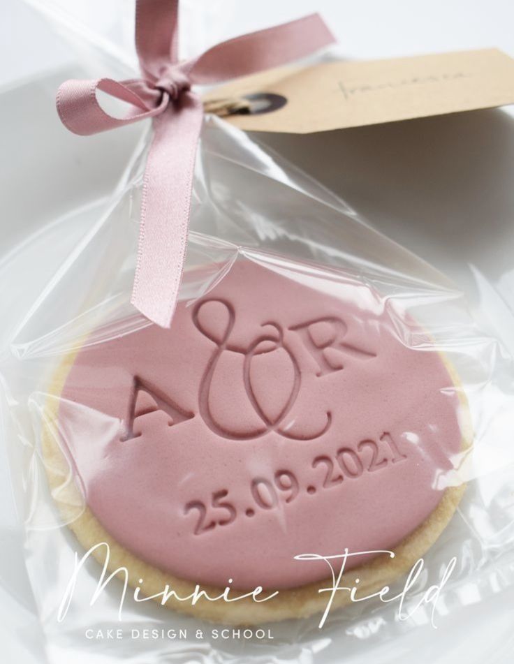 a cookie with a pink frosting on it and a tag attached to the top