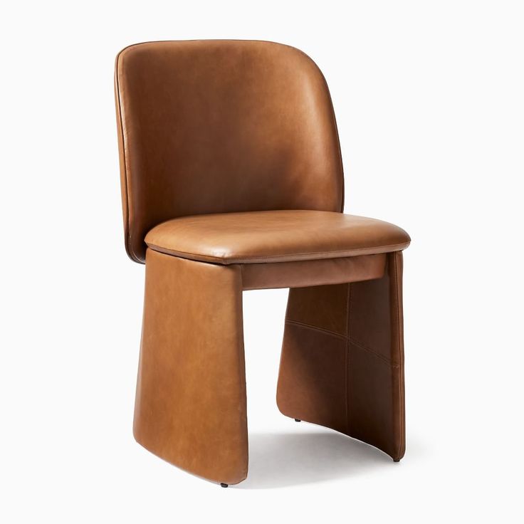 a brown leather chair sitting on top of a white floor