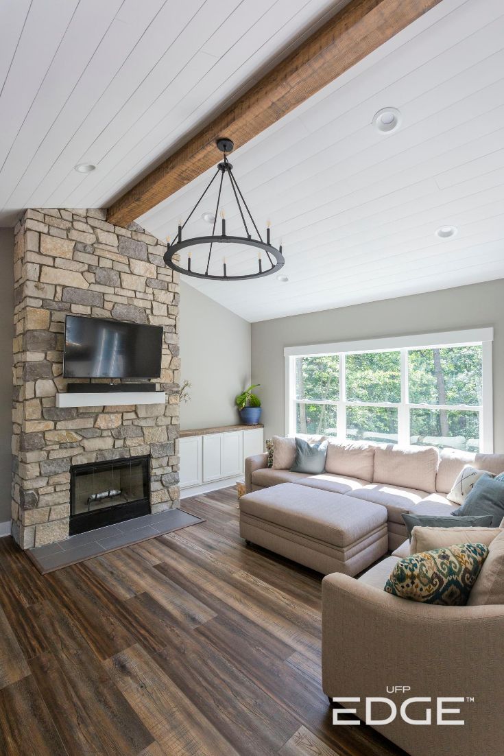 a living room with wood floors and a stone fireplace