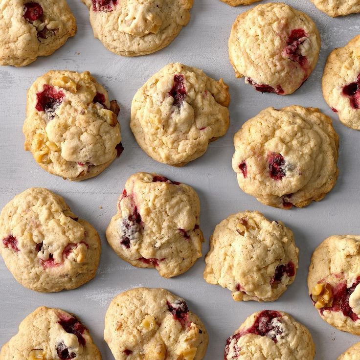 several cookies with cranberry toppings are lined up on a baking sheet and ready to be baked