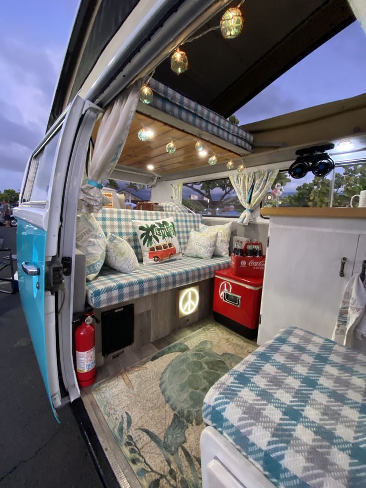 the interior of a camper van with couches and pillows on the bed area