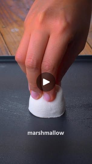 a person is placing marshmallows on top of each other