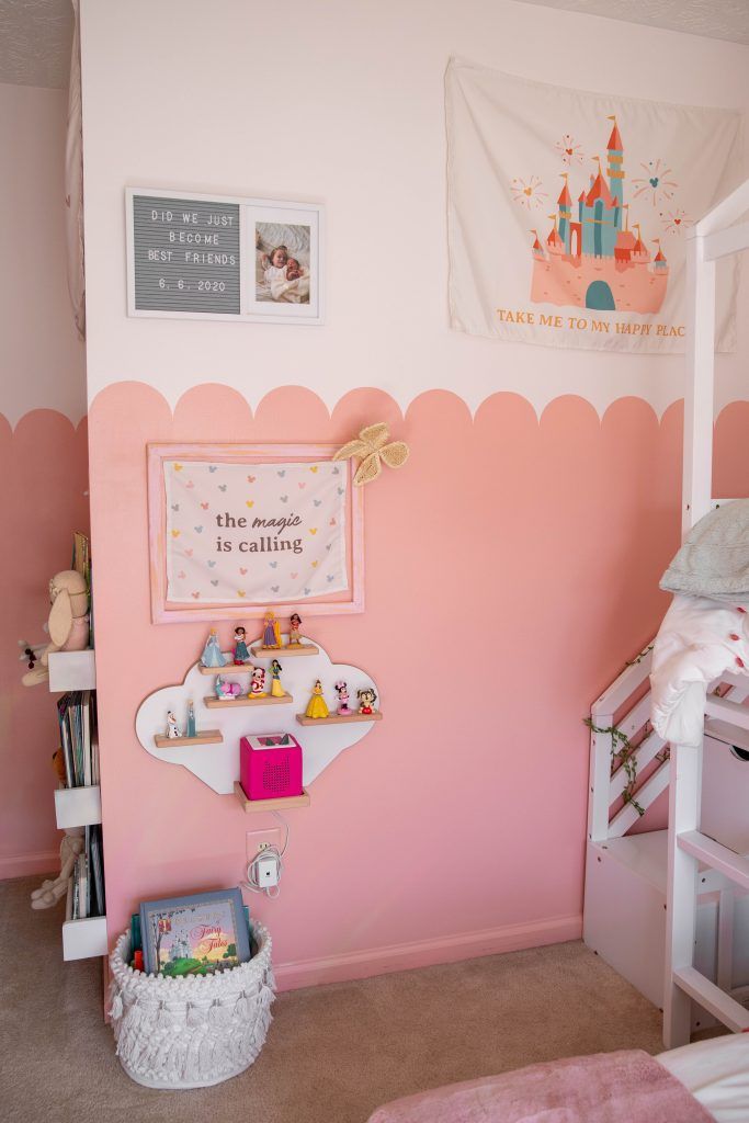 a child's bedroom with pink walls and white furniture