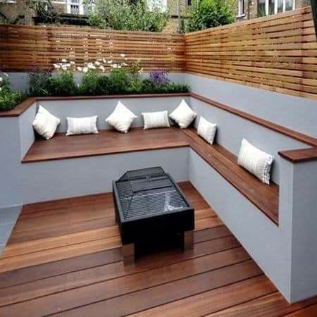 a wooden bench sitting on top of a hard wood floor next to a fire pit