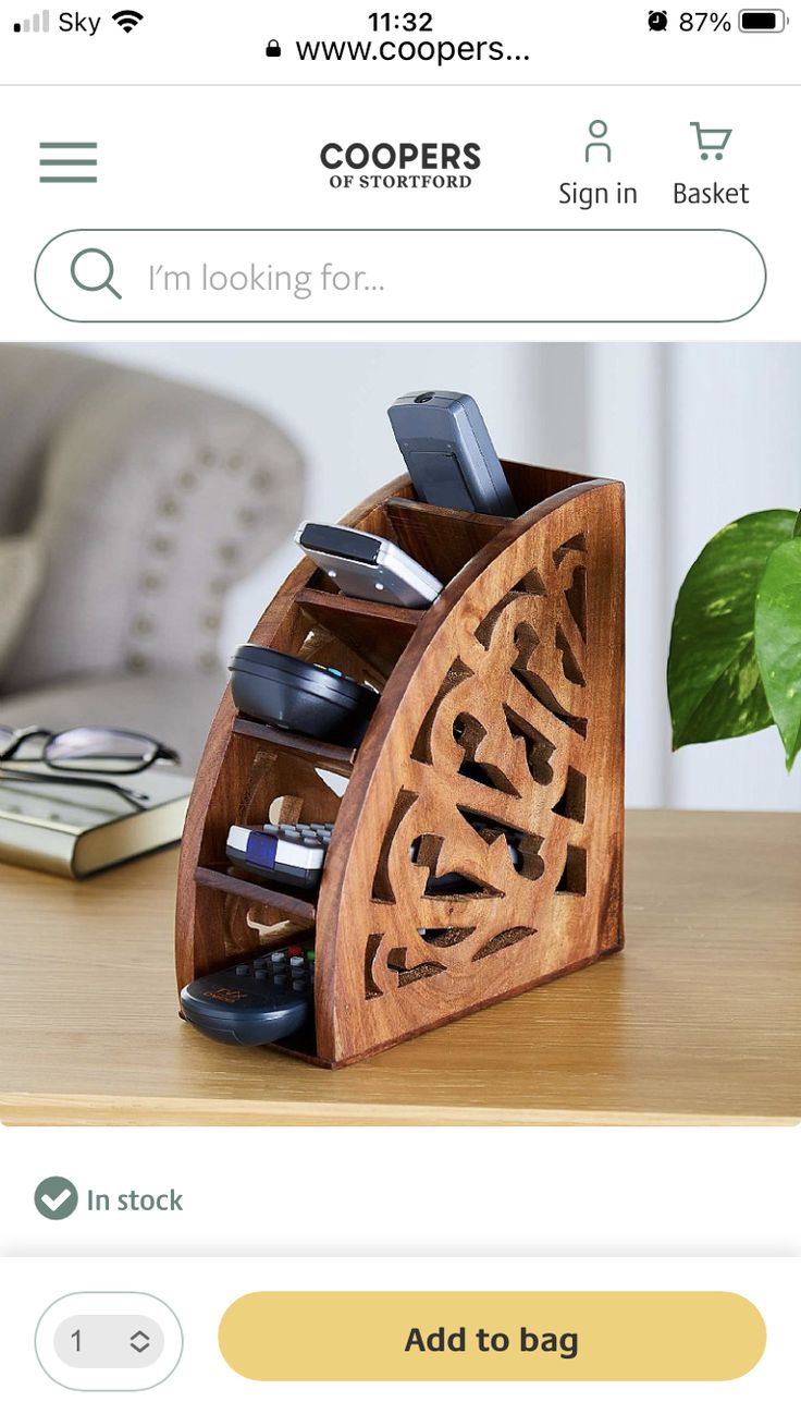 a wooden phone holder with cell phones in it