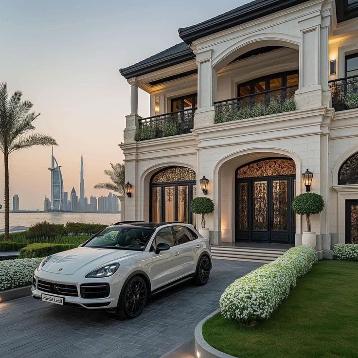 a white porsche cayen is parked in front of a house with a view of the city