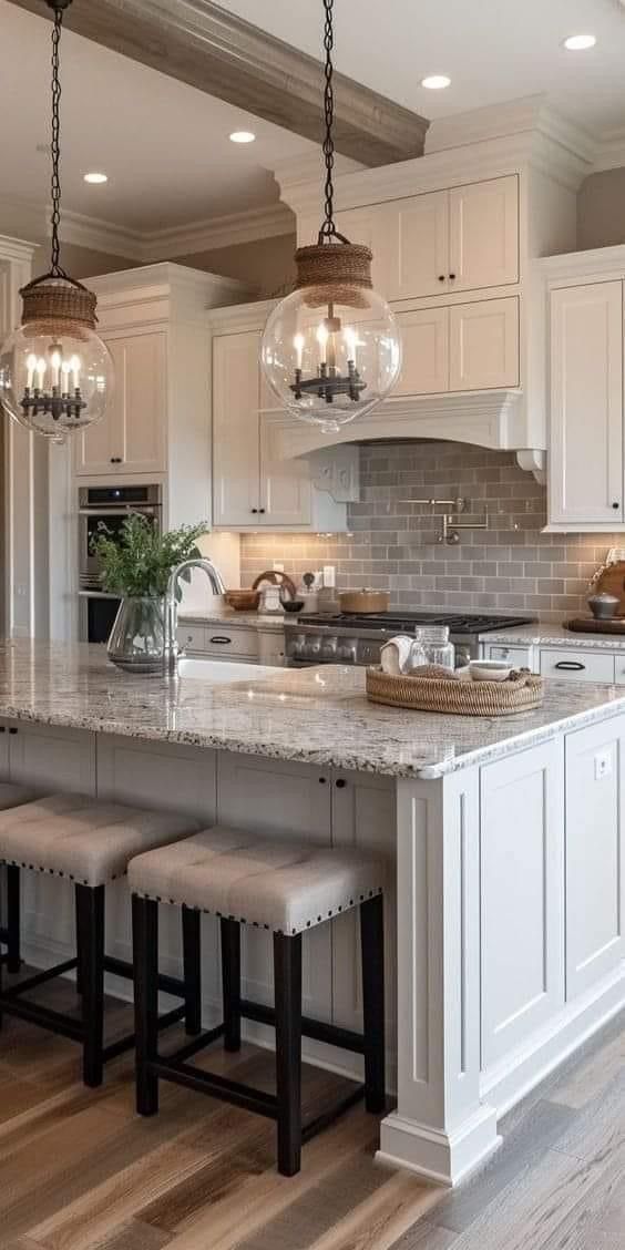 a large kitchen with white cabinets and an island in the middle is surrounded by stools