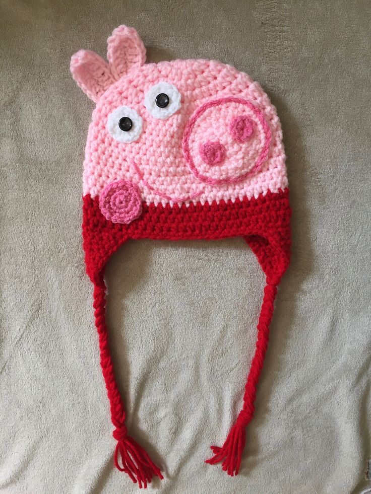 a crocheted pig hat on top of a bed