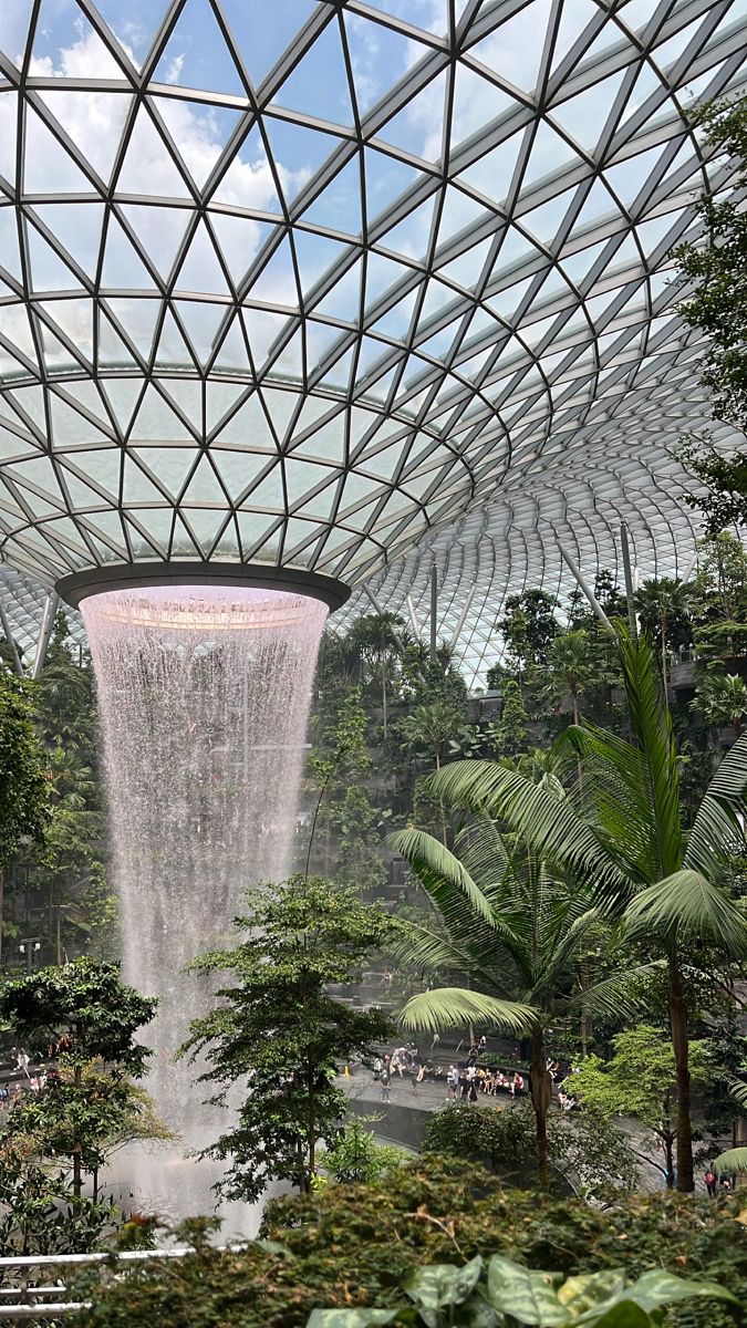 an indoor waterfall in the middle of a tropical garden