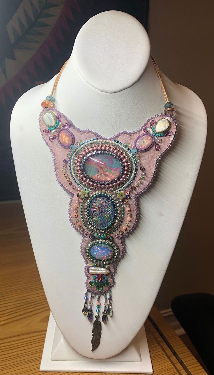 a white mannequin with a pink necklace on it's neck and beads