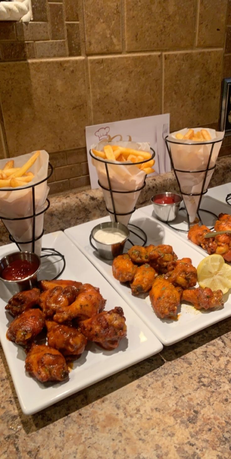 four trays filled with different types of food on a counter top in a kitchen