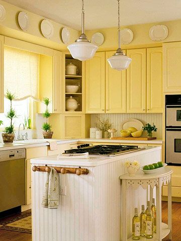 a kitchen with yellow cabinets and white appliances