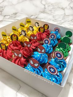 a box filled with cupcakes decorated like captain america