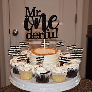 a cake and cupcakes on a table with a sign that says mr onederful