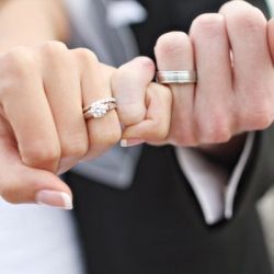 black and white photograph of a woman holding her engagement ring in one hand with the other