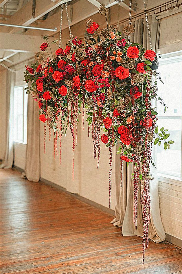 red flowers hanging from the ceiling in an empty room