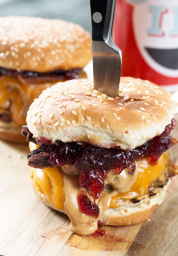 a cheeseburger is being cut by a knife