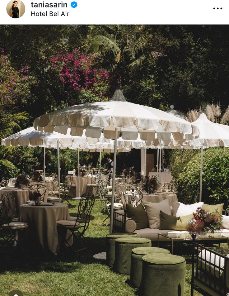 an outdoor seating area with umbrellas and tables set up for a party or social gathering