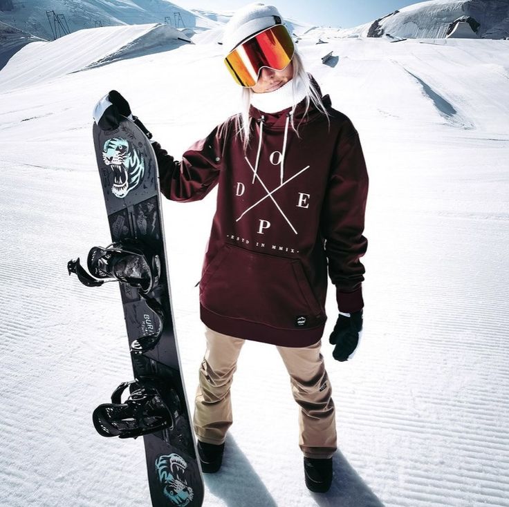 a man holding a snowboard while standing in the snow