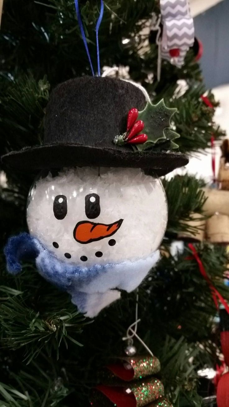 a snowman ornament hanging on a christmas tree in the shape of a hat