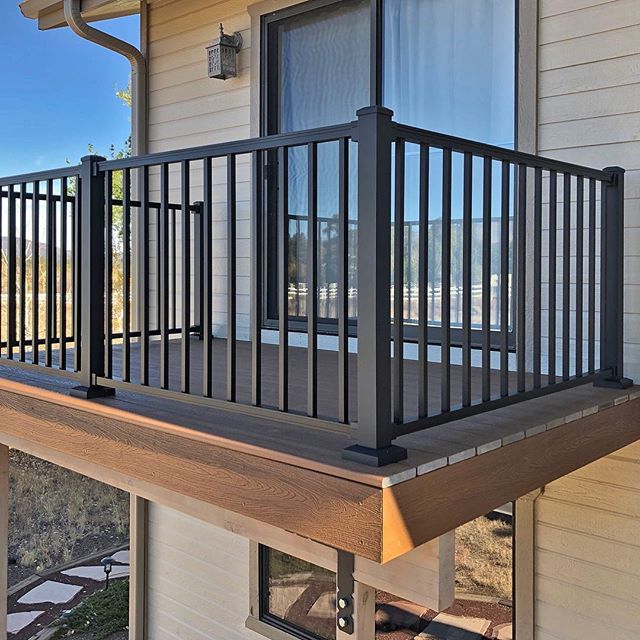 a balcony with metal railings on the side of a house