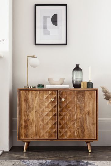 a wooden cabinet sitting next to a white wall