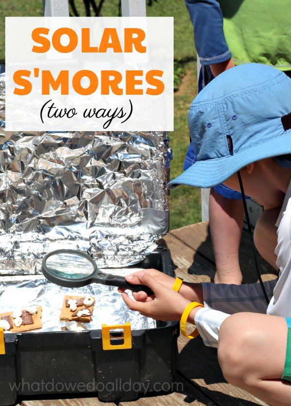 two people looking at some food in a box with the words solar s'mores on it