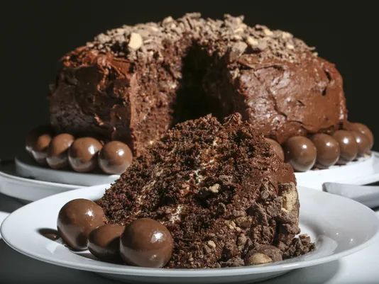 there is a chocolate bundt cake on the plate and it has two pieces cut out