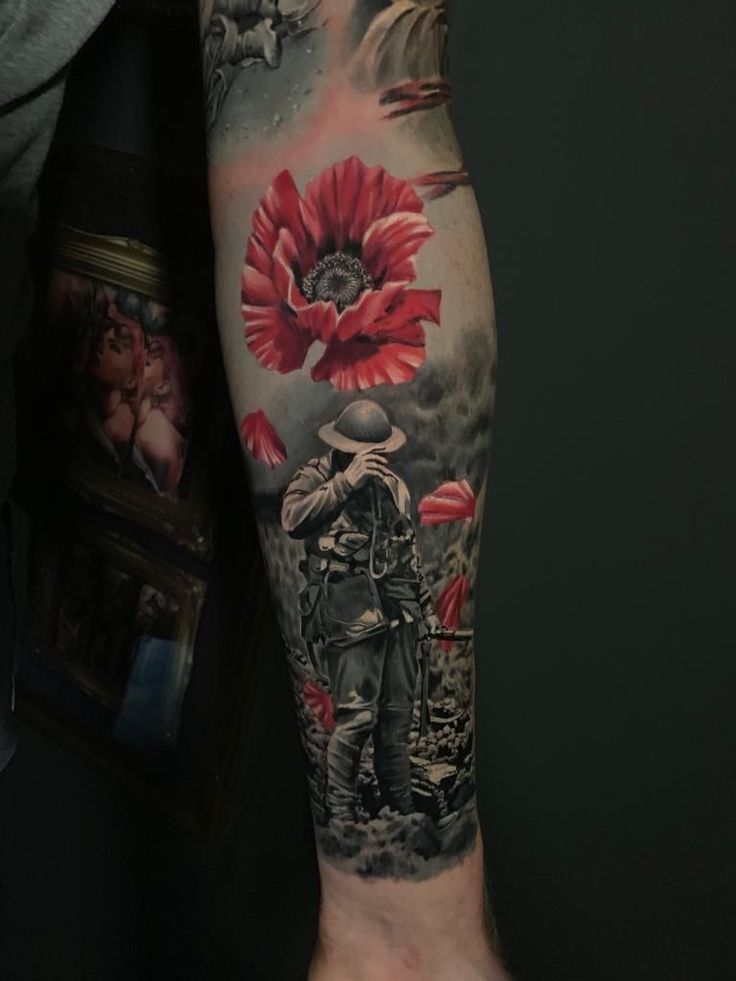 a man with a tattoo on his arm holding a red flower in front of him