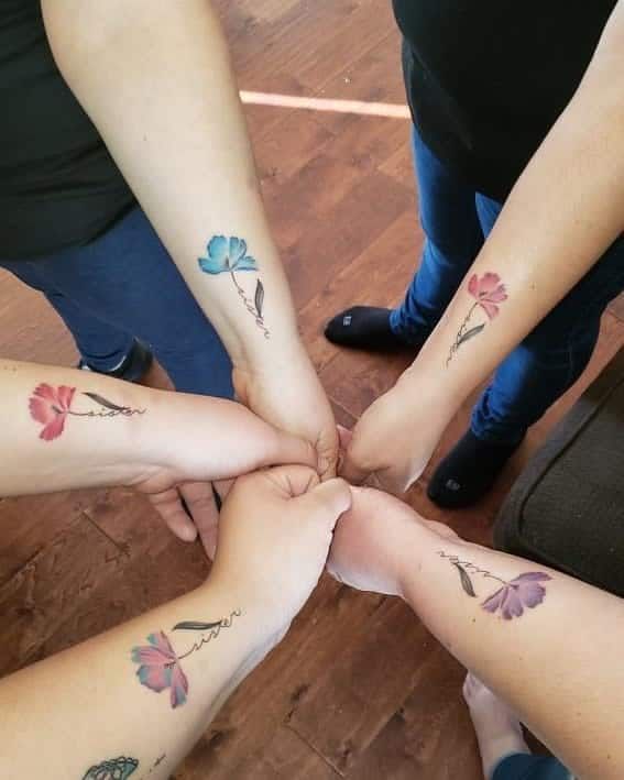 several people holding hands together with tattoos on their arms