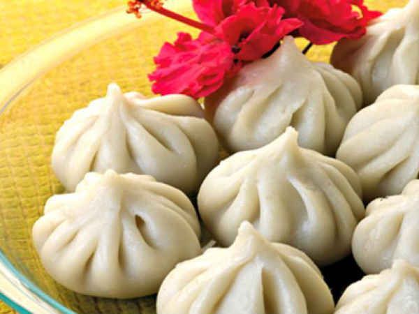 three dumplings on a glass plate with a red flower in the middle and another one sitting behind it