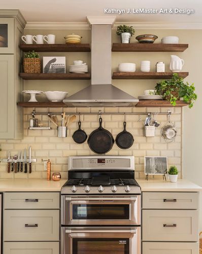 a stove top oven sitting inside of a kitchen next to wooden shelves filled with pots and pans