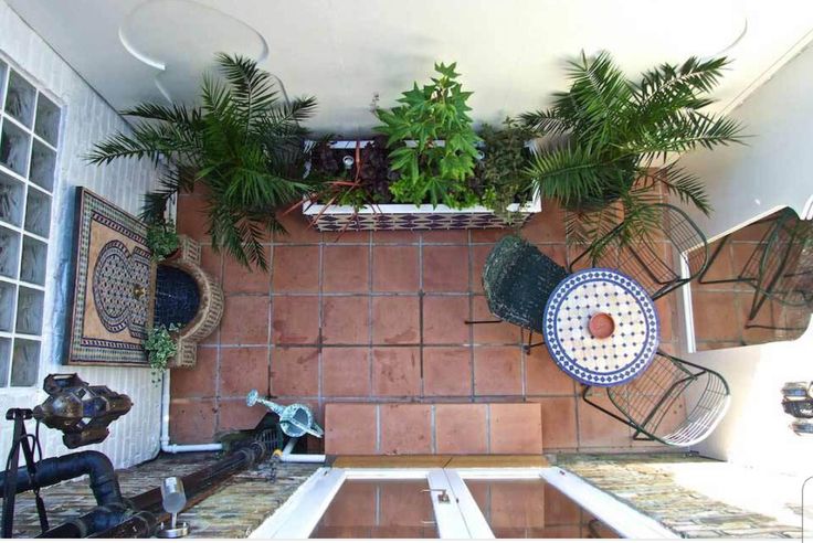 a kitchen with tiled floors and plants on the counter top, along with potted plants