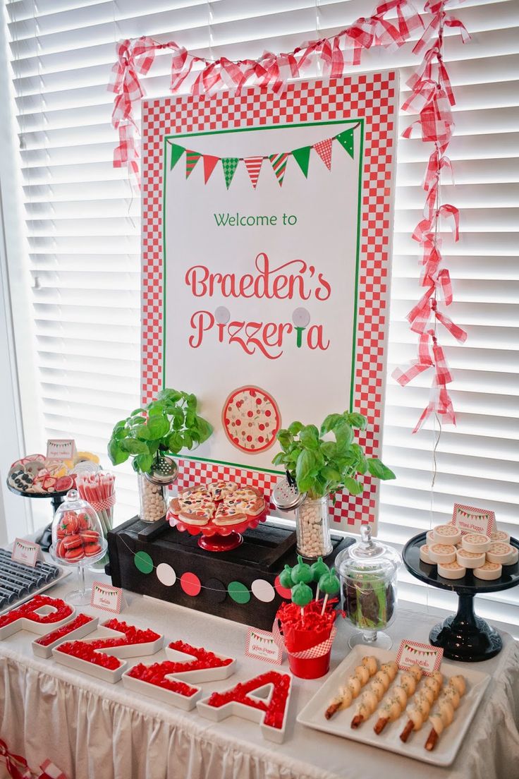 a welcome sign and dessert table for a children's pizza party with red, white and green decorations